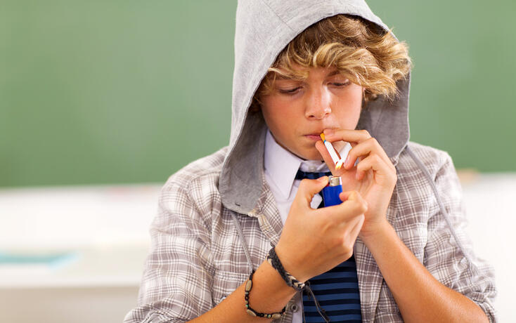 teen boy lighting cigarette