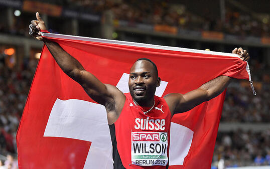 Alex Wilson feiert mit Schweizer Fahne seine Bronzemedaille