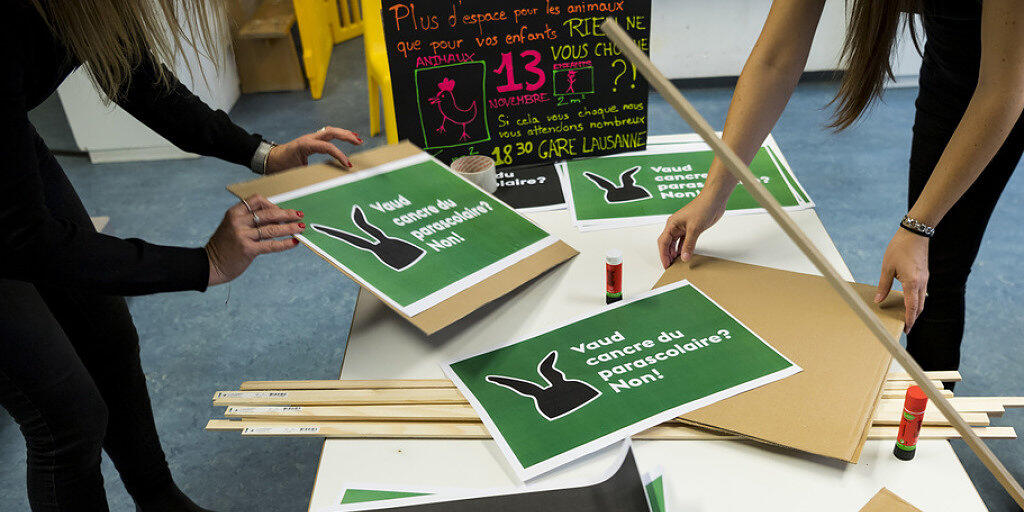 Mitarbeiterinnen einer Kindertagesstätte bereiten Plakate für die Kundgebung in Lausanne vor.