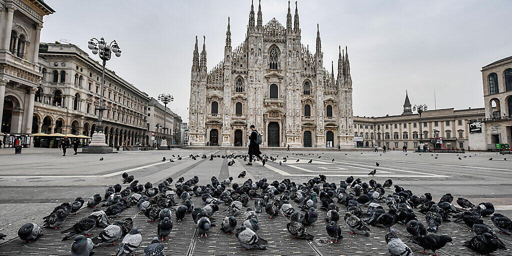 dpatopbilder - Nur wenige Menschen halten sich auf dem Platz vor dem Mailänder Dom auf. In Italien sind verschärfte Corona-Schutzvorschriften in Kraft getreten. Die Regierung hat eine nächtliche Ausgangssperre verhängt und in vier Regionen trat ein Teil-Lockdown in Kraft, der rund um die Uhr gilt. Foto: Claudio Furlan/LaPresse via ZUMA Press/dpa