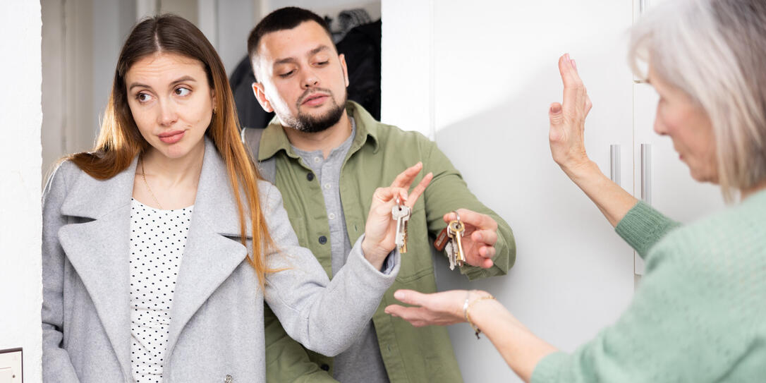 Dissatisfied owner receiving keys from married couple tenants