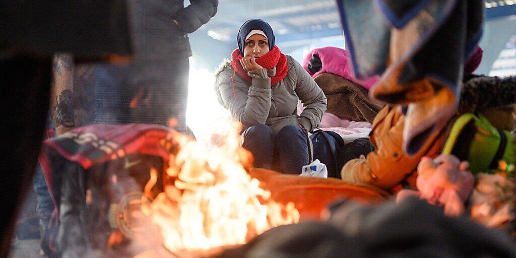 ARCHIV - Eine Frau aus Syrien sitzt an einem Lagerfeuer in einer leeren Markthalle nahe der türkisch-griechischen Grenze. Foto: Mohssen Assanimoghaddam/dpa ARCHIV - Eine Frau aus Syrien sitzt an einem Lagerfeuer in einer leeren Markthalle nahe der türkisch-griechischen Grenze. Foto: Mohssen Assanimoghaddam/dpa
