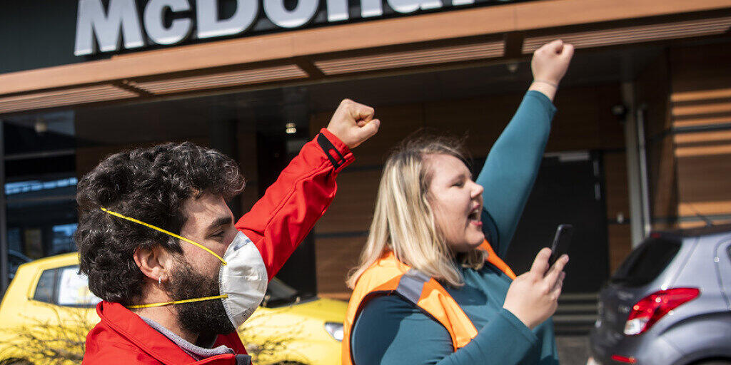 Mitglieder der Gewerkschaft Unia protestieren gegen "inakzeptable Arbeitsbedingungen" beim McDrive in Crissier VD.