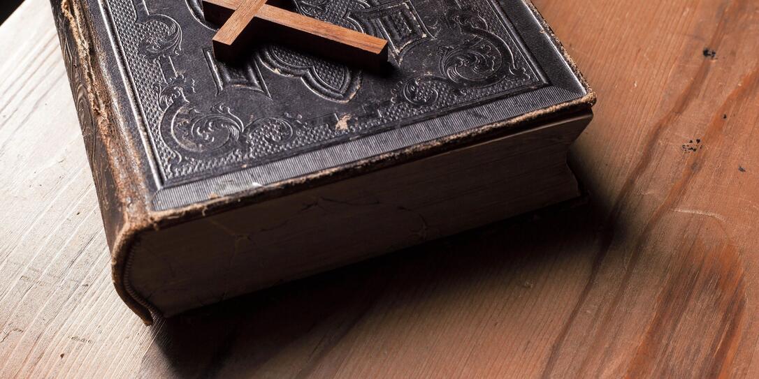 Old holy bible with wooden Christian cross