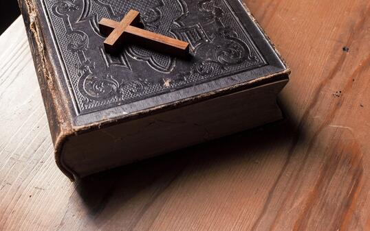 Old holy bible with wooden Christian cross