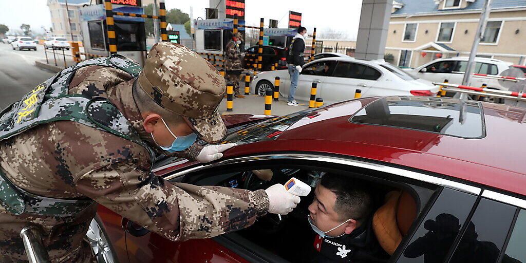 Strenge Massnahmen zur Eindämmung der Lungenkrankheit: An einer Mautstelle in Wuhan lässt ein Autofahrer seine Körpertemperatur kontrollieren.