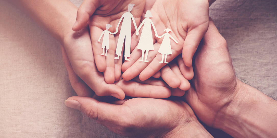 Adult and children hands holding paper family cutout, family home, foster care, homeless charity support concept Adult and children hands holding paper family cutout, family home, foster care, homeless charity support concept