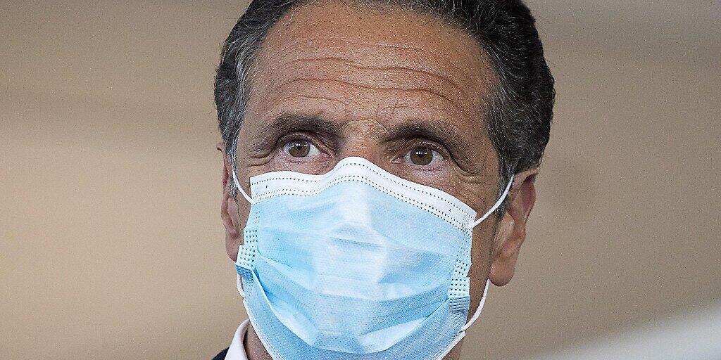 ARCHIV - Andrew Cuomo, Gouverneur von New York, trägt während einer Pressekonferenz im Terminal B des Laguardia-Flughafens einen Mundschutz. (zu dpa "Corona-Pandemie: New Yorks Gouverneur wirbt mit Stars für Masken") Foto: Mark Lennihan/AP/dpa
