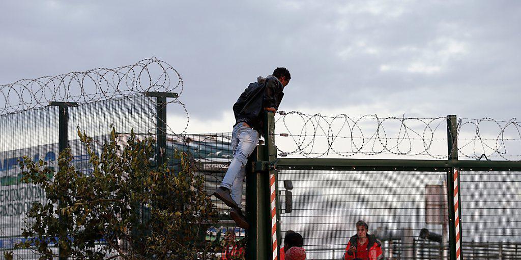 Hunderte Migranten versuchen jede Nacht in Calais, auf einen Güterzug Richtung Grossbritannien zu gelangen. Daran gehindert werden sie durch Abschrankungen und von einem Grossaufgebot an Polizisten.
