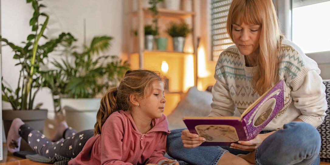 Mother and little daughter enjoying book together Mother and little daughter enjoying book together