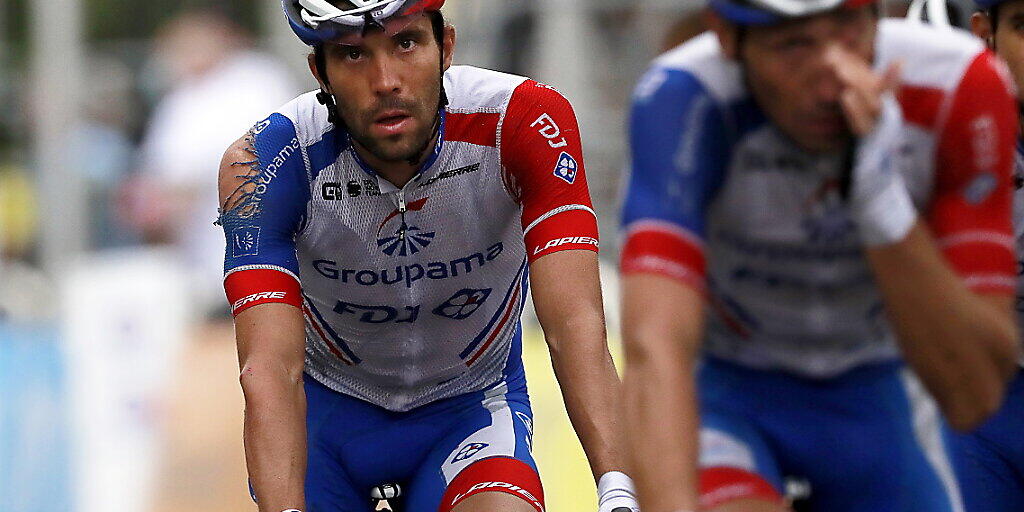 Thibault Pinot (links) mit dem zerfetzten Shirt überquert nach dem Sturz zu Beginn der Tour der France frustriert die Ziellinie.