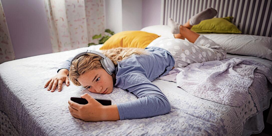 Teenager girl sitting in her bed feeling lonely and sad Teenager girl sitting in her bed feeling lonely and sad