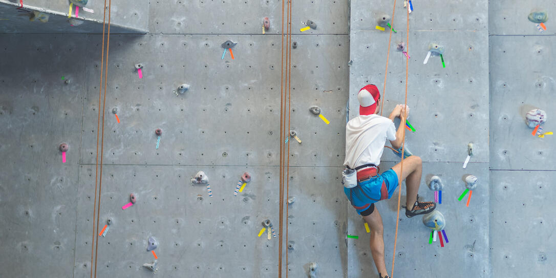 College student scaling indoor climbing wall College student scaling indoor climbing wall