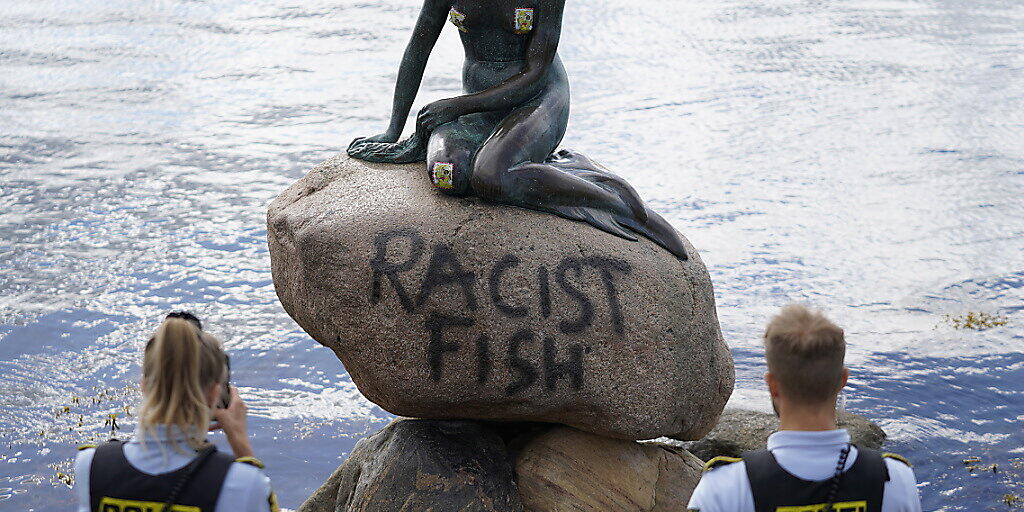 Polizeibeamte stehten an der Statue der kleinen Meerjungfrau, die von Unbekannten mit dem Schriftzug «Racist Fish» (Rassistischer Fisch) beschmiert wurde. Für politische Statements wurde die kleine Nixe schon häufiger missbraucht. (zu dpa "Stein der Kleinen Meerjungfrau in Kopenhagen beschmiert") Foto: Mads Claus Rasmussen/Ritzau Scanpix/AP/dpa