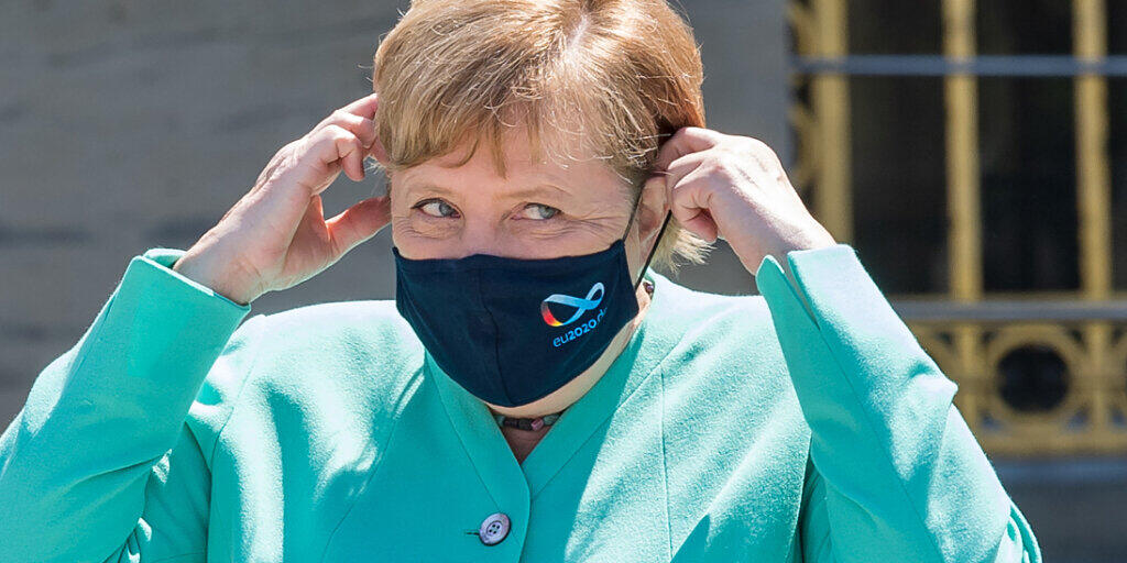Bundeskanzlerin Angela Merkel (CDU) setzt sich vor Beginn der bayerischen Kabinettssitzung auf der Insel Herrenchiemsee ihre Mund-Nase-Schutzmasken auf. Foto: Peter Kneffel/dpa/Pool/dpa