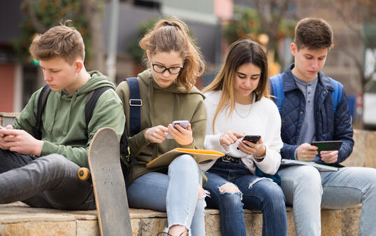 Teenagers chatting on their smartphone on walking