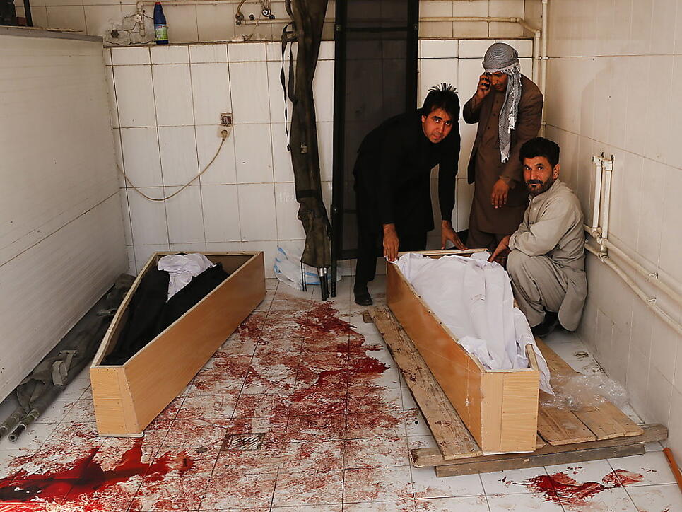 Verwandte betten ein Opfer eines Selbstmordanschlags in Kabul in einen Sarg - Noch nie wurden in Afghanistan so viele Zivilisten bei Gefechten oder Anschlägen getötet wie im ersten Halbjahr 2018. (Archiv)