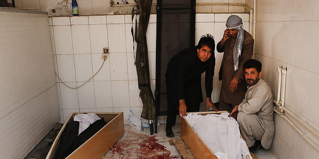 Verwandte betten ein Opfer eines Selbstmordanschlags in Kabul in einen Sarg - Noch nie wurden in Afghanistan so viele Zivilisten bei Gefechten oder Anschlägen getötet wie im ersten Halbjahr 2018. (Archiv)