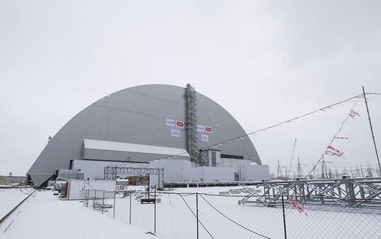 Die neue Schutzhülle um die Atomruine in Tschernobyl steht. Sie wurde mit einem Hydrauliksystem auf Spezialschienen über den havarierten Reaktor geschoben.