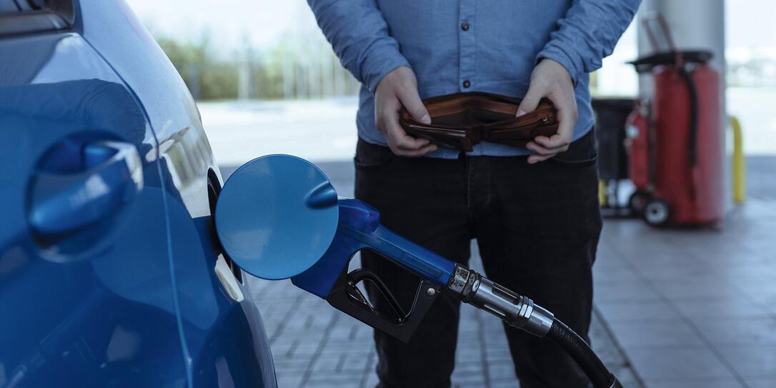refueling a car with gasoline at a gas station. Rise in fuel prices. Crisis and lack of gasoline. A man holds an empty wallet near the car refueling a car with gasoline at a gas station. Rise in fuel prices. Crisis and lack of gasoline. A man holds an empty wallet near the car