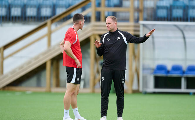 Trainer Marc Schneider (r.) im Gespr&auml;ch mit Daniel Kasper im Abschlusstraining.