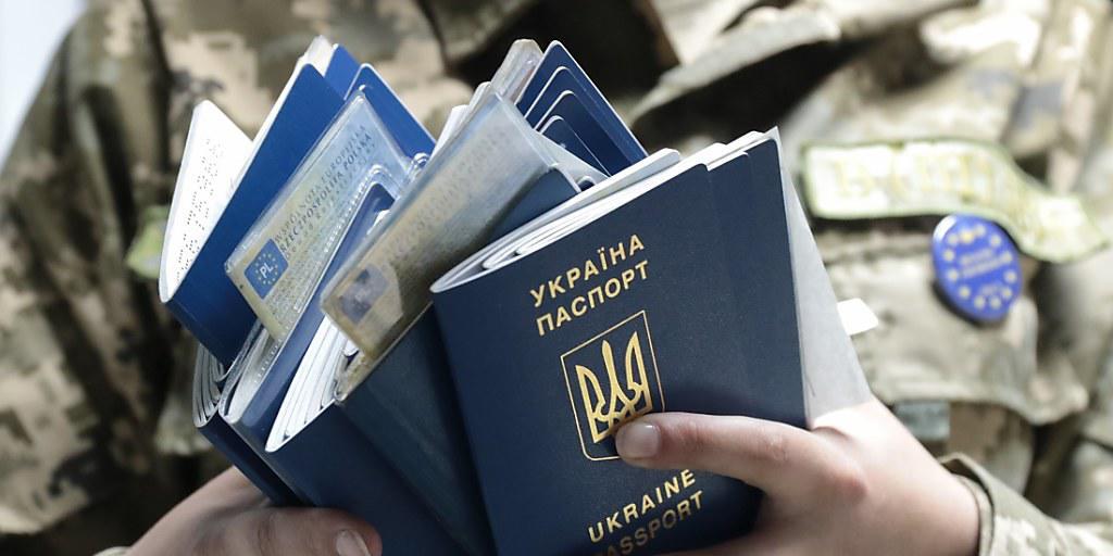Ein polnischer Zöllner beim Grenzübergang Rava-Ruska prüft einen Stapel ukrainischer Pässe: Seit Sonntag dürfen Ukrainerinnen und Ukrainer ohne Visum 90 Tage als Touristen im Schengenraum verbringen.