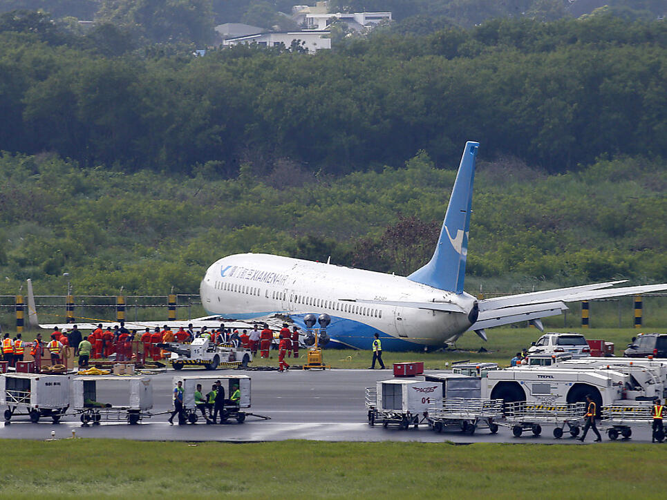Über die Landebahn hinaus gerutscht: Die Maschine der chinesischen Fluggesellschaft Xiamen Airlines liegt nach der missglückten Landung neben der Piste im Gras.