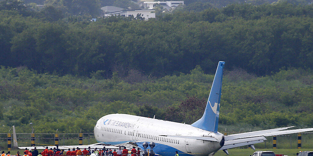 Über die Landebahn hinaus gerutscht: Die Maschine der chinesischen Fluggesellschaft Xiamen Airlines liegt nach der missglückten Landung neben der Piste im Gras.